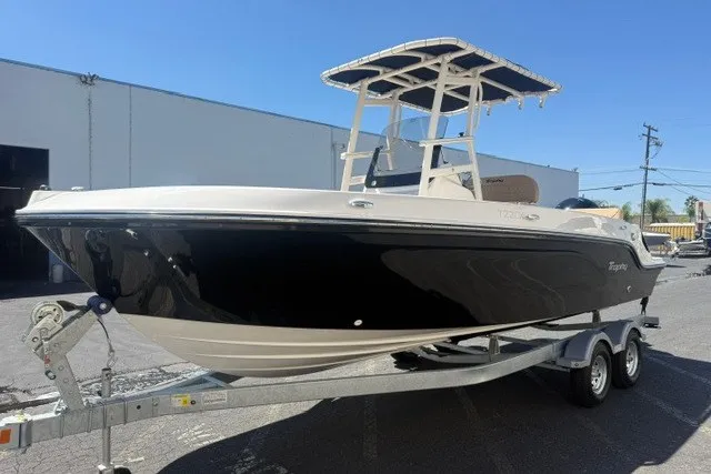 Slide: The Image of 2026 Bayliner Trophy T22CX boat on trailer, black hull, parked outdoors. - 21