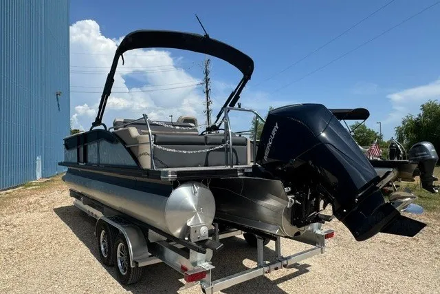 Slide: The Image of 2027 Barletta Aria 24UC pontoon boat on trailer, featuring a powerful outboard motor. - 5