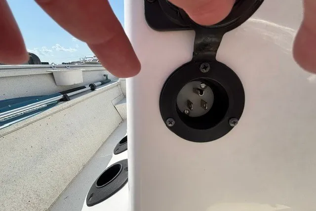 Slide: The Image of 2019 G3 Bay 20 boat power socket close-up with hand nearby. - 22