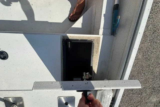 Slide: The Image of 2019 G3 Bay 20 boat deck with open storage compartment and visible foot. - 13