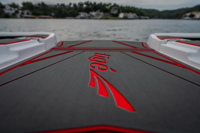 Slide: The Image of 2027 Tigé Ultré 25ZX boat deck with red accents on a lake. - 46