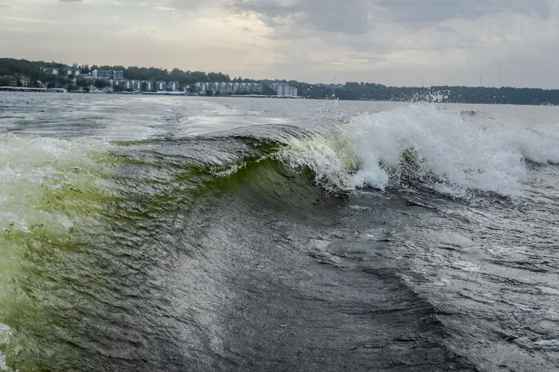 Slide: The Image of Waves created by the 2027 Tige Ultré 25ZX boat on a scenic lake. - 16