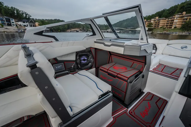 Slide: The Image of 2027 Tigé Ultré 25ZX boat interior with modern seating and sleek design on a scenic lake. - 68