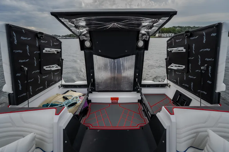 Slide: The Image of 2027 Tigé Ultré 25ZX boat interior with open storage compartments on a lake. - 47