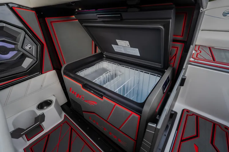 Slide: The Image of Interior of 2027 Tige Ultré 25ZX boat featuring a built-in cooler and stylish design. - 18