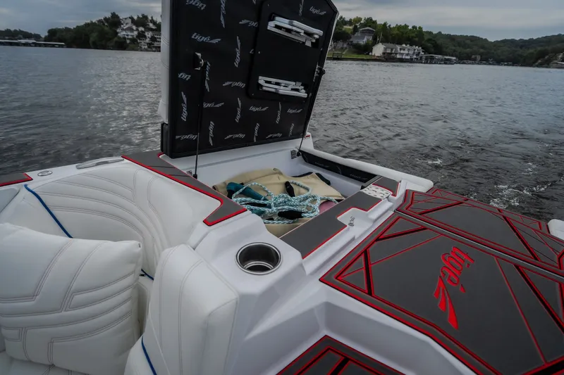 Slide: The Image of 2027 Tigé Ultré 25ZX boat interior with open storage, white seating, and lake view. - 45