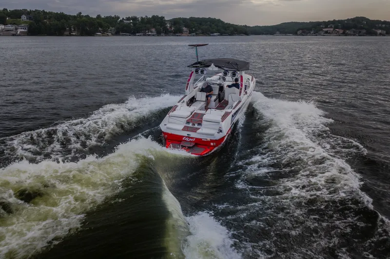 Slide: The Image of 2027 Tige Ultré 25ZX boat cruising on a scenic lake. - 7