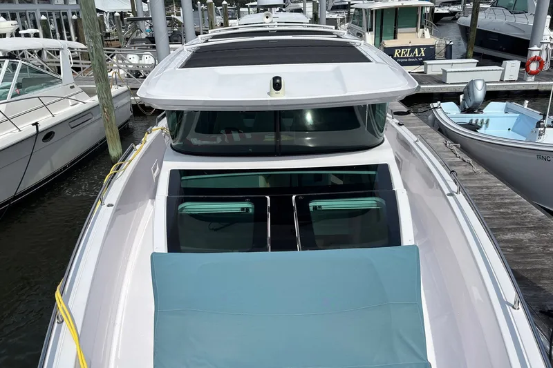 Slide: The Image of 2023 Axopar 45 XC Cross Cabin docked at marina, showcasing sleek design and spacious deck. - 34