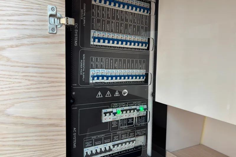 Slide: The Image of Electrical panel inside 2023 Axopar 45 XC Cross Cabin, showcasing DC and AC systems. - 13