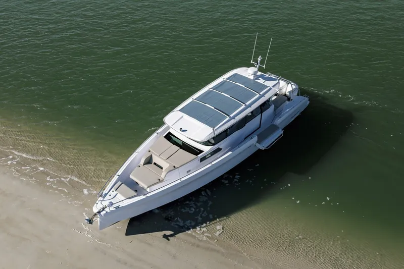 Slide: The Image of 2023 Axopar 45 XC Cross Cabin boat on sandy shore, aerial view. - 2