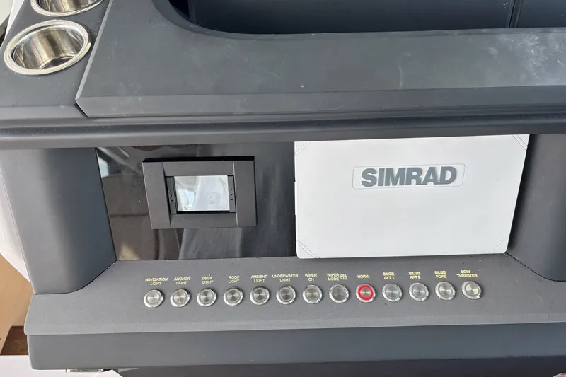 Slide: The Image of Control panel of 2023 Axopar 45 XC Cross Cabin with Simrad display and various switches. - 12