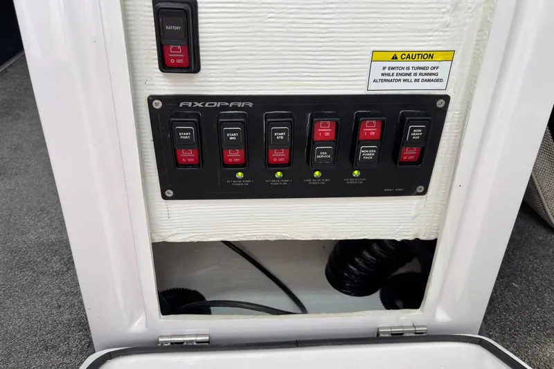 Slide: The Image of Control panel of 2023 Axopar 45 XC Cross Cabin with labeled switches and caution sign. - 15