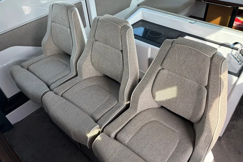 Slide: The Image of 2023 Axopar 45 XC Cross Cabin interior with three plush gray seats. - 16