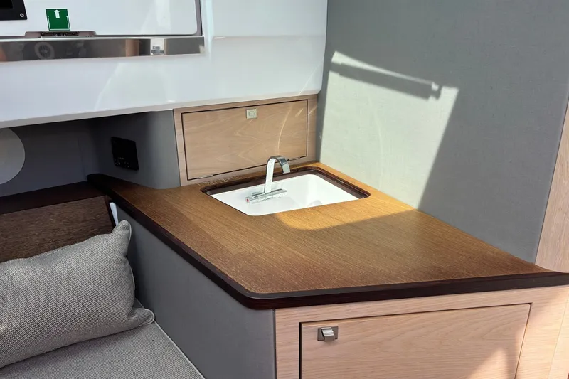 Slide: The Image of 2023 Axopar 45 XC Cross Cabin interior with modern sink and wooden countertop. - 23