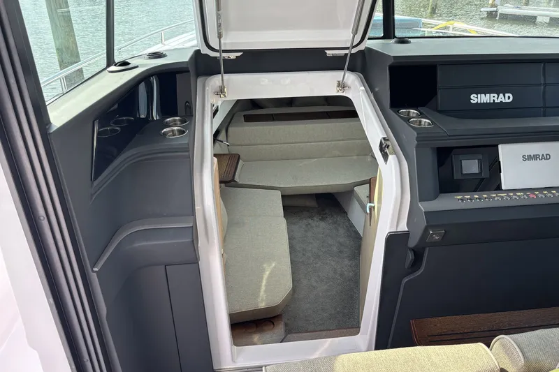 Slide: The Image of 2023 Axopar 45 XC Cross Cabin interior with Simrad navigation system and cozy seating area. - 20
