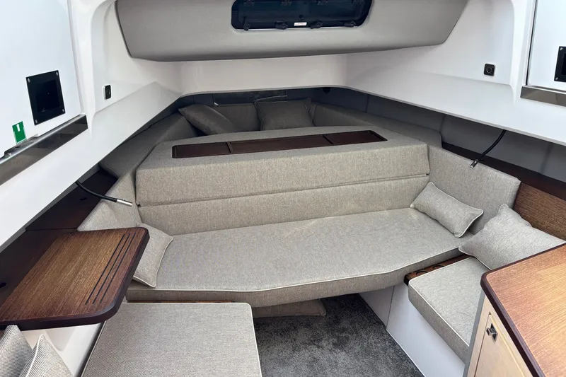 Slide: The Image of 2023 Axopar 45 XC Cross Cabin interior with beige seating and wooden accents. - 21