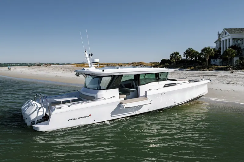 The Image of 2023 Axopar 45 XC Cross Cabin boat docked on a sandy beach. - 1