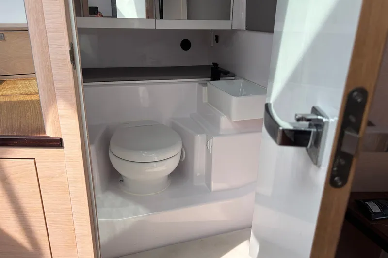 Slide: The Image of 2023 Axopar 45 XC Cross Cabin bathroom interior with modern fixtures and compact design. - 25