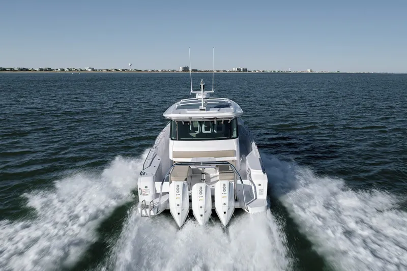 Slide: The Image of 2023 Axopar 45 XC Cross Cabin cruising on open water, rear view. - 41
