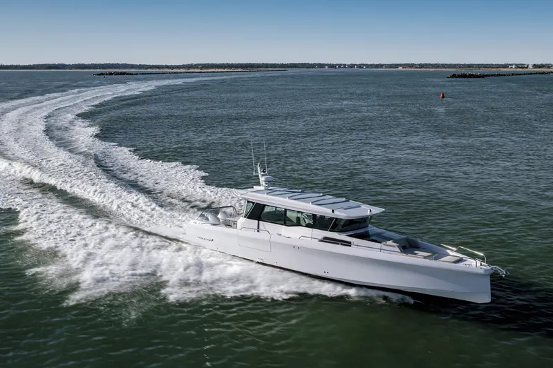 Slide: The Image of 2023 Axopar 45 XC Cross Cabin cruising on open water, creating a dynamic wake. - 5