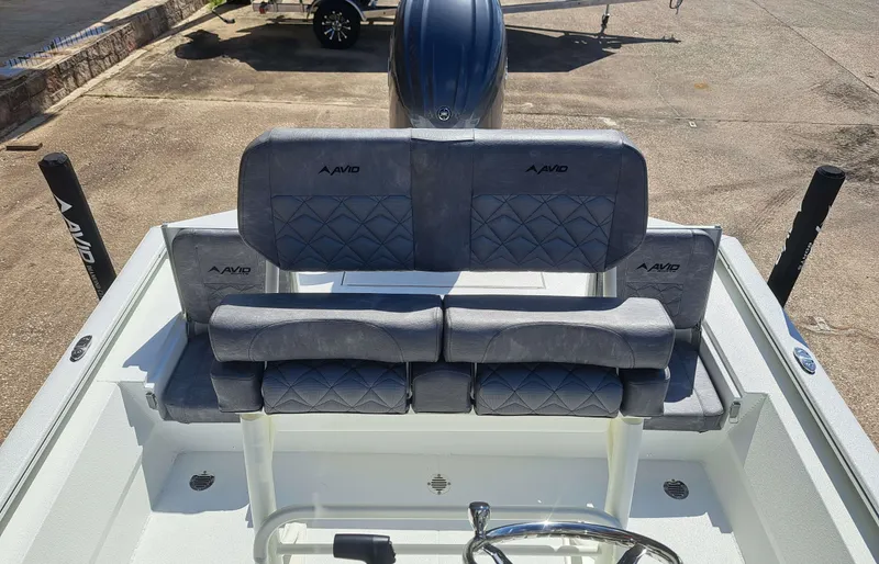 Slide: The Image of The image shows the cockpit of an Avid 21MAG ST boat with gray upholstery and a helm station. - 14