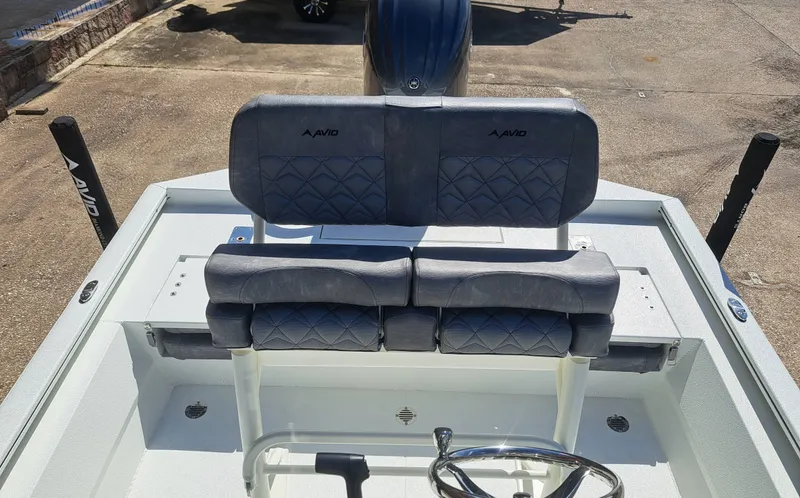 Slide: The Image of The image shows the cockpit of an Avid 21MAG ST boat with gray upholstered seats. - 13