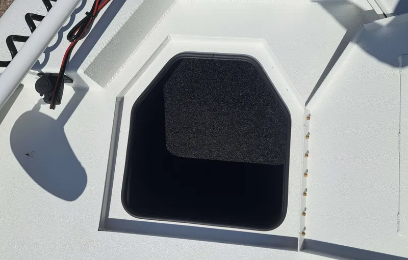 Slide: The Image of An open storage compartment on a white boat with a black interior. - 17