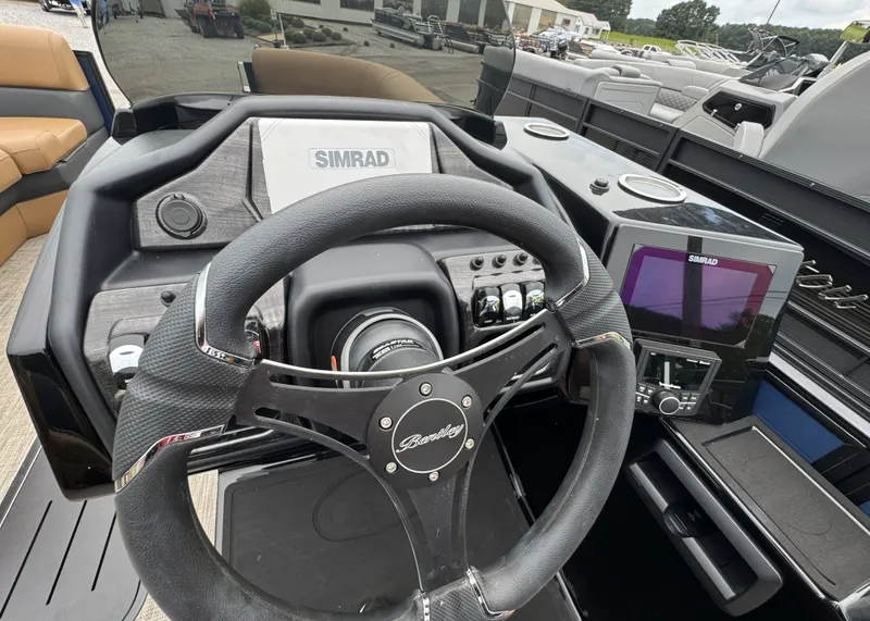 Slide: The Image of The image shows the helm of a Bentley Pontoons Elite 223 SwingBack DC with Simrad electronics. - 10