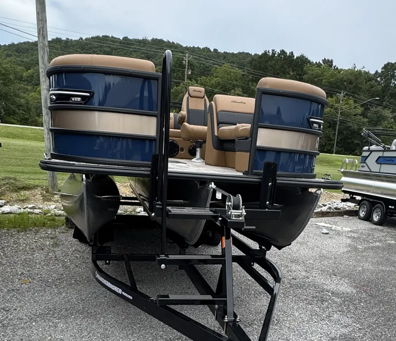 Slide: The Image of A 2026 Bentley Pontoons Elite 223 SwingBack DC on a trailer, featuring blue and beige upholstery. - 5
