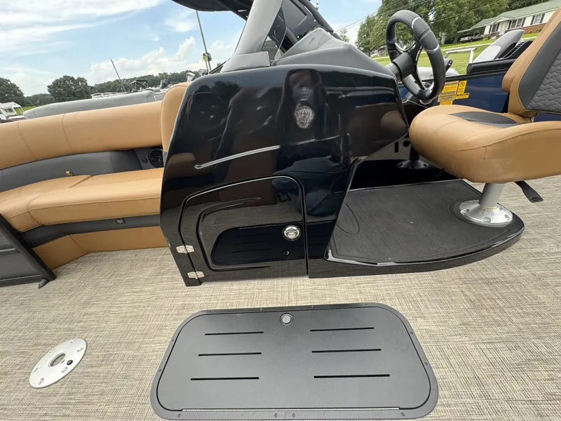 Slide: The Image of Interior of a Bentley Pontoons Elite 223 SwingBack DC with brown seats and black helm console. - 11