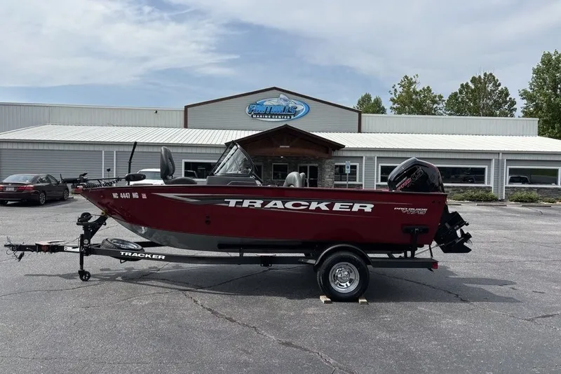 The Image of 2025 Tracker Pro Guide V-175 Combo boat on trailer, parked outside a marine dealership. - 2