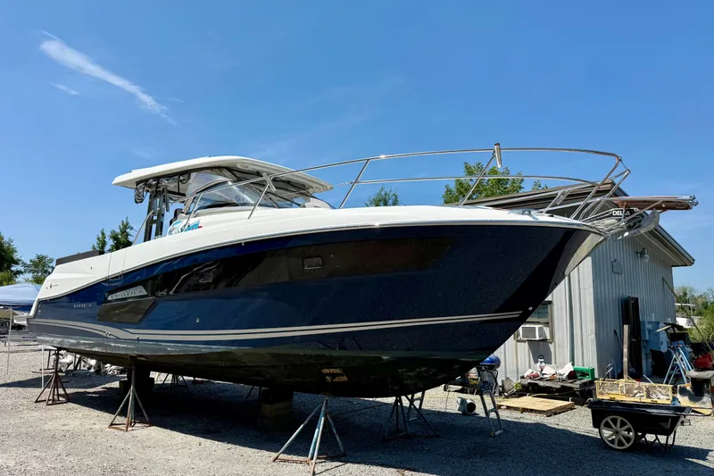 The Image of 2022 Jeanneau Leader 12.5 WA boat on stands, outdoors under clear blue sky. - 0
