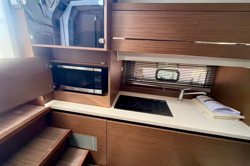 Slide: The Image of Modern kitchen interior of 2022 Jeanneau Leader 12.5 WA yacht with microwave and stovetop. - 13