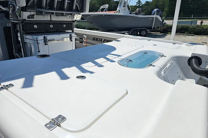 Slide: The Image of 2026 Sea Pro 250 Bay boat deck with storage compartments and seating area. - 11