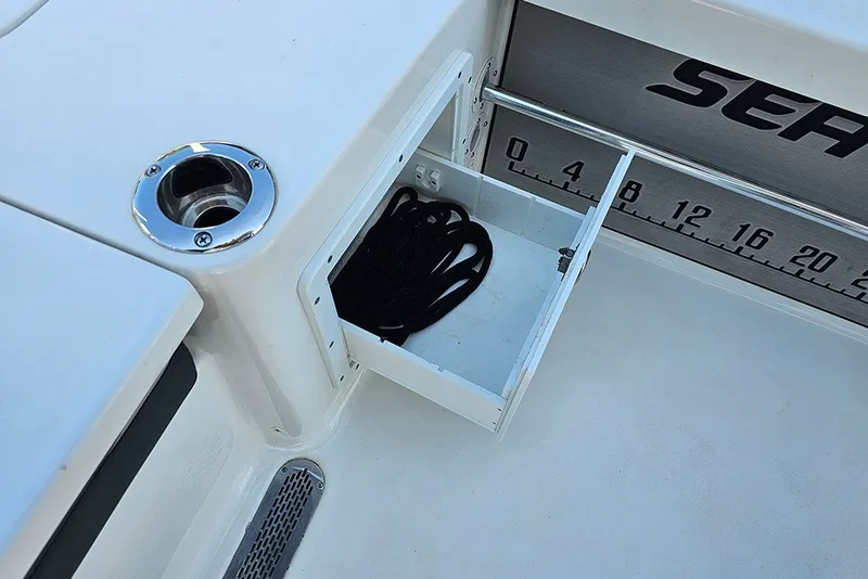Slide: The Image of Storage compartment on 2026 Sea Pro 250 Bay boat with measuring scale and cup holder. - 16