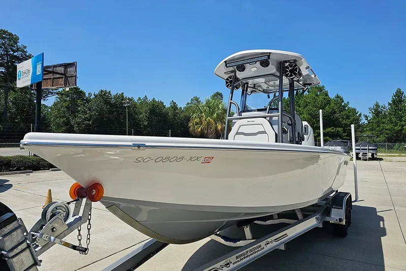 Slide: The Image of 2026 Sea Pro 250 Bay boat on trailer, parked outdoors under clear blue sky. - 6