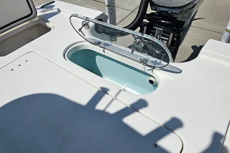Slide: The Image of 2026 Sea Pro 250 Bay boat with open livewell and visible engine components. - 14