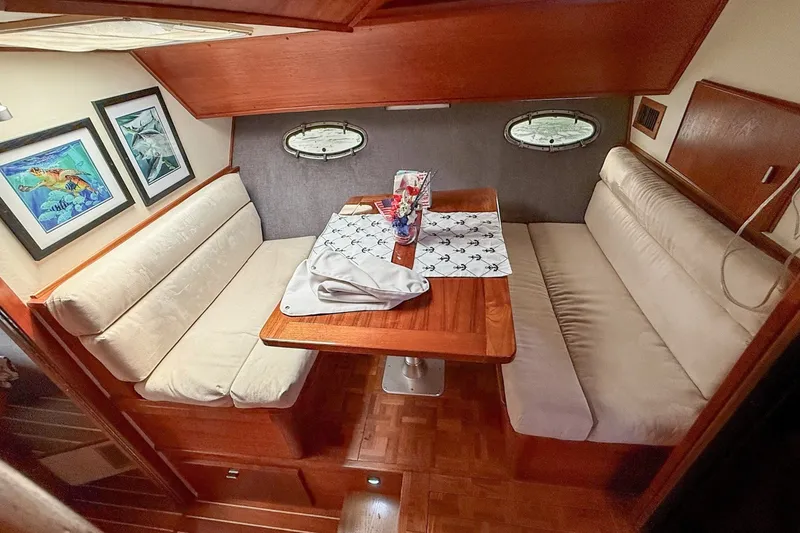 Slide: The Image of 1989 Tiara Yachts 3600 Convertible interior with cozy dining area and nautical decor. - 38