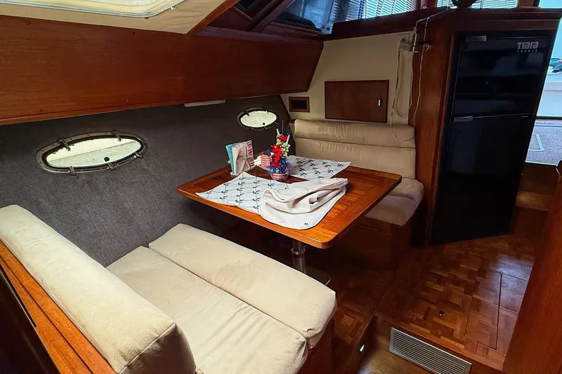 Slide: The Image of Interior of 1989 Tiara Yachts 3600 Convertible with cozy dining area and wood accents. - 40