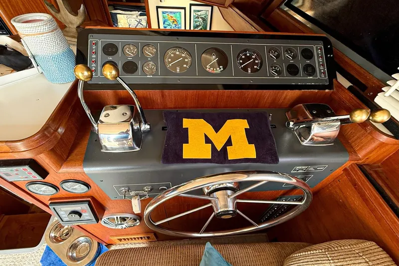 Slide: The Image of Helm of 1989 Tiara Yachts 3600 Convertible with nautical controls and Michigan emblem. - 24
