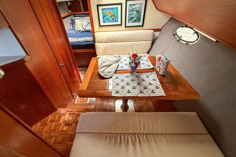Slide: The Image of 1989 Tiara Yachts 3600 Convertible interior with cozy dining area and nautical decor. - 39