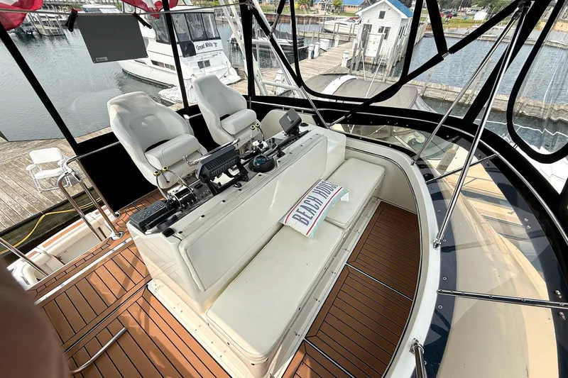 Slide: The Image of 1989 Tiara Yachts 3600 Convertible helm with seating, overlooking marina. - 15