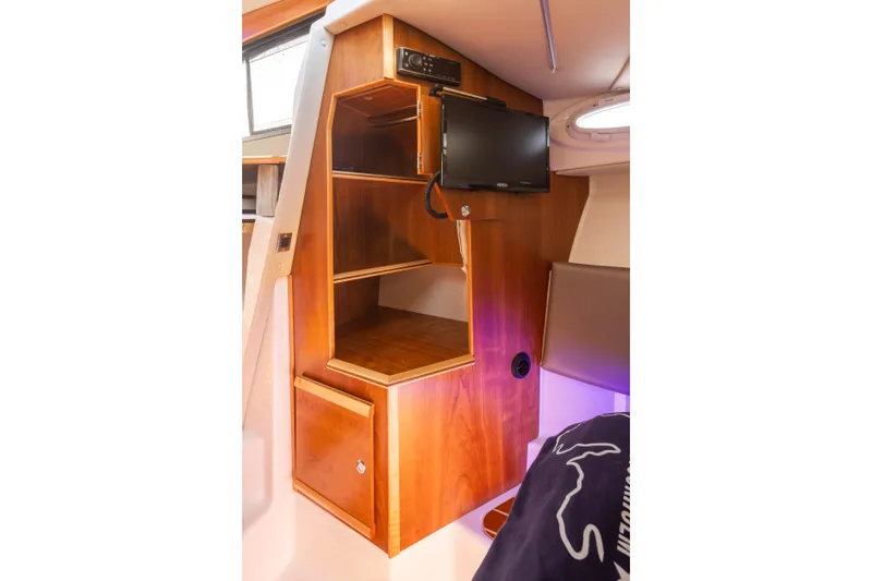Slide: The Image of 2023 Cutwater C-30 Sedan interior with wooden cabinetry and mounted TV. - 38