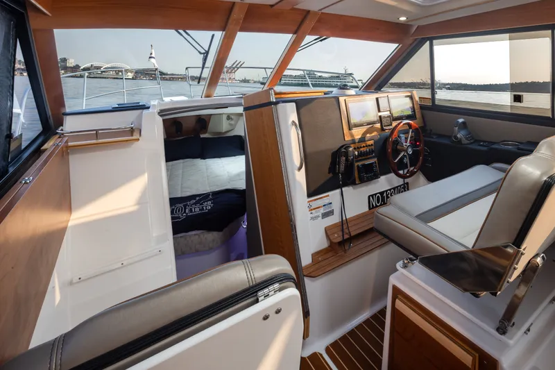 Slide: The Image of Interior of 2023 Cutwater C-30 Sedan boat, featuring helm and cabin with waterfront view. - 35