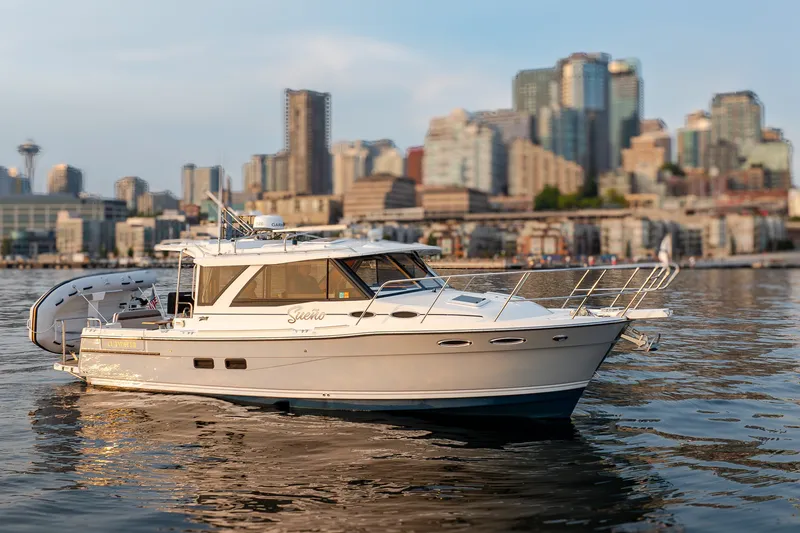 The Image of 2023 Cutwater C-30 Sedan boat on water with city skyline backdrop. - 0