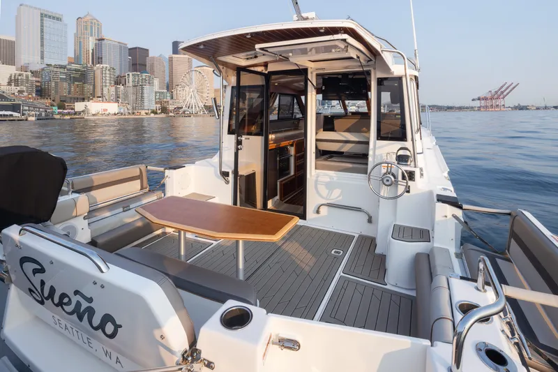 Slide: The Image of 2023 Cutwater C-30 Sedan yacht docked in Seattle, featuring spacious deck and city skyline. - 19