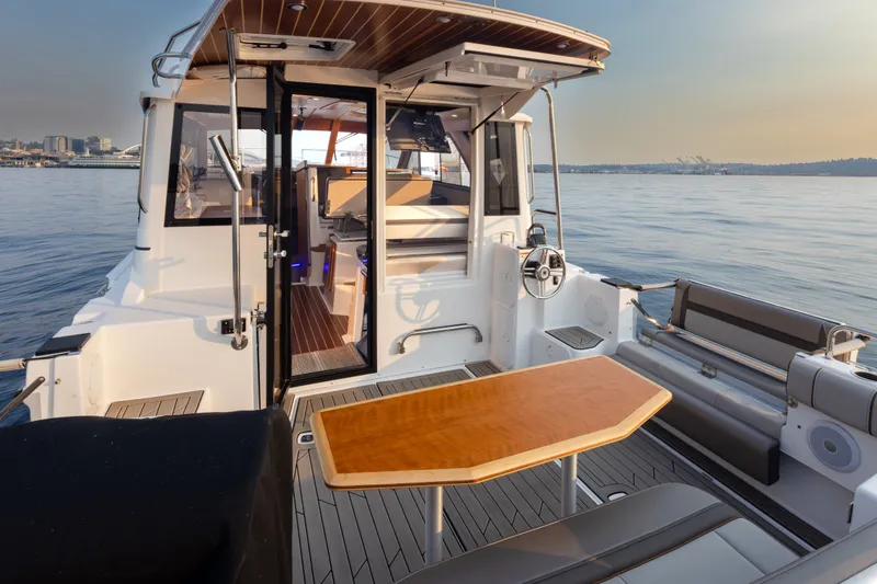 Slide: The Image of 2023 Cutwater C-30 Sedan boat interior with table, overlooking calm waters. - 23