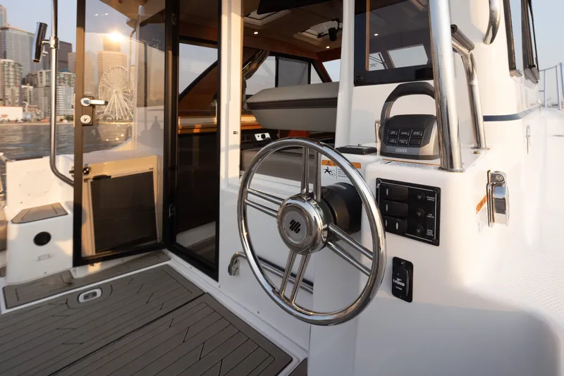 Slide: The Image of 2023 Cutwater C-30 Sedan boat interior with steering wheel and city skyline view. - 47