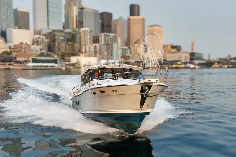 Slide: The Image of 2023 Cutwater C-30 Sedan cruising in urban waterfront setting. - 14