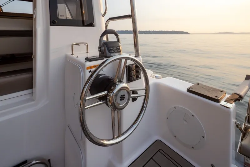 Slide: The Image of Steering wheel of 2023 Cutwater C-30 Sedan boat with serene water view. - 46